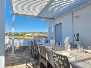 a dining room with a table and chairs on a patio at Villetta Tina Private Pool - Torre Pali in Torre Pali