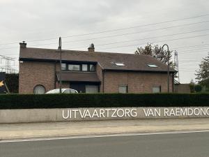 a brick house with a sign in front of it at Steves Place Haasdonk in Beveren