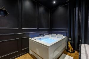 a bathroom with a white sink and black walls at Le Spa Nocturne in Le Petit-Quevilly