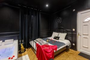 a bedroom with black walls and a bed with red sheets at Le Spa Nocturne in Le Petit-Quevilly