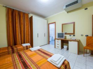 a bedroom with a bed and a desk and a television at Fruit Village Capo Rizzuto S Antonio in Capo Rizzuto