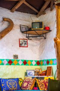 a room with a couch and a tv on a shelf at Traditional Berber Eco Farm Stay in Agadir +61 photos