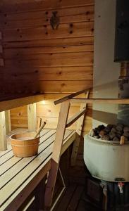 a sauna with a tub and a wooden wall at Rantakorpi Farm in Niemisjärvi