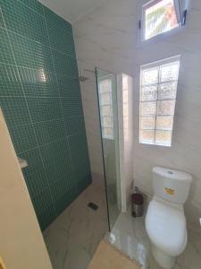 ein Badezimmer mit Toilette und Glasdusche in der Unterkunft Casa Cacheu Homestay in Bissau