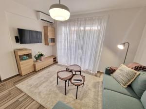 a living room with a couch and two tables at Triumph 1 - A in Paralimni +7 photos