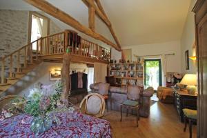 a living room with a staircase and a couch at Kernad in Bersac-sur-Rivalier