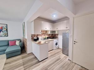 a kitchen with white cabinets and a blue couch at Triumph 1 - A in Paralimni