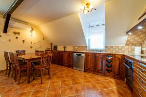 a kitchen with a table and wooden cabinets and a table and chairs at LAKE VIEW House in Mikołajki +13 photos