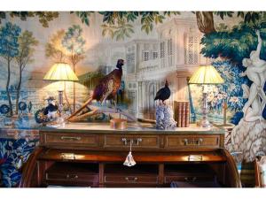 a wooden dresser with two birds on top of it at Château d'Hodebert in Saint-Paterne-Racan