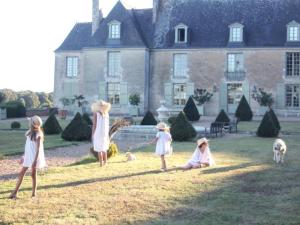 a group of children playing in the grass in front of a house at Château d'Hodebert in Saint-Paterne-Racan