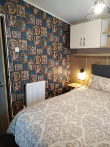 a bedroom with a bed and a wall of plates at Dog Friendly Holiday Home in Northampton