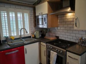 a kitchen with a sink and a stove top oven at Dog Friendly Holiday Home in Northampton