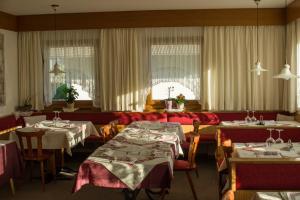 a dining room with two tables and chairs and a room with tablesktop at Pension Apartments Klotznerhof in Schenna