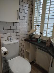 a white bathroom with a toilet and a sink at Dog Friendly Holiday Home in Northampton +7 photos