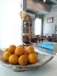 a bowl of oranges on a plate on a table at Loft Life Pool villa in Ban Huai Yai