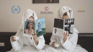 a person dressed in a robe reading a book at Hotel Borowiecki in Łódź