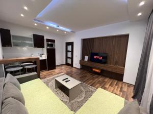 a living room with a couch and a tv at Central View Prishtina in Prishtinë
