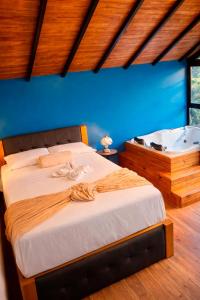 a bedroom with a bed and a bath tub at La Finca De Frida in Guatapé