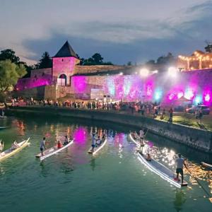 a group of boats in the water in front of a building at Riverside Panorama Apartment 1 near City Center Brko 1 in Banja Luka +25 photos