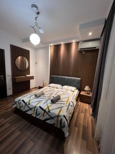 a bedroom with a bed and a wooden floor at Central View Prishtina in Prishtinë
