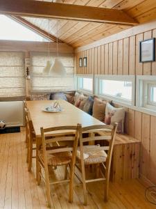 a dining room with a wooden table and chairs at Mountain Cabin With Glacier Views in Norheimsund