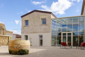 a building with glass windows and a table and chairs at CASA ioio in Jaunay-Clan