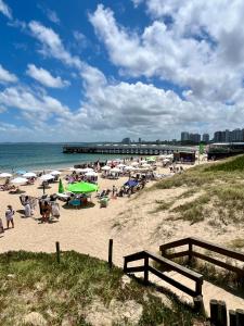 a beach with a bunch of people on the sand at Edificio Carbe Punta del Este - Frente al Mar -parada 2 de la Mansa in Punta del Este