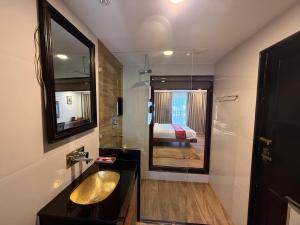 a bathroom with a sink and a mirror and a bed at Ambassador Garden Home in Kathmandu +105 photos