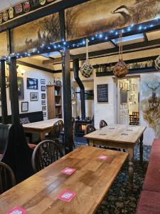 a dining room with wooden tables and a fireplace at The Rockford Inn in Lynton