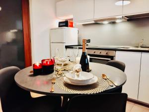 a table with a bottle of wine and wine glasses at Charming Central Relais in Bergamo