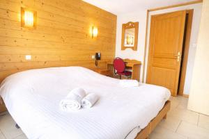 a bedroom with a bed with two towels on it at Hôtel Résidence La Maison par Les Pins Sylvestres Amnéville les Thermes in Amnéville