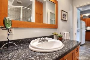 a bathroom counter with a sink and a mirror at Charming and cozy cottage at Maple Beach in Point Roberts