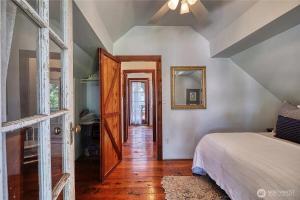 a bedroom with a bed and a mirror on the wall at Charming and cozy cottage at Maple Beach in Point Roberts