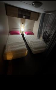two beds in a small room with a flashlight at My Freedom in Hyères