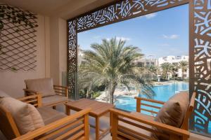 a balcony with chairs and a view of a pool at VESTA - El Gouna Residence in Hurghada