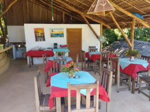 a restaurant with tables and chairs with red napkins at Colibri Lodge in Ambatoloaka