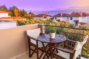 a table and two chairs on a balcony with a plant at Evripidis Hotel Afitos in Afitos