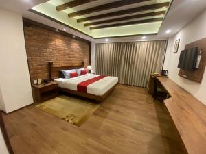 a bedroom with a bed and a brick wall at Ambassador Garden Home in Kathmandu