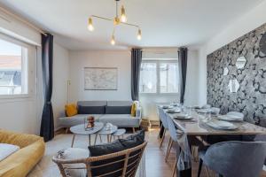 a living room with a table and a couch at Le Stanislas 61 - Spacieux & Cosy in Nancy +11 photos
