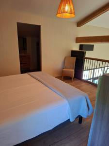 ein Schlafzimmer mit einem großen Bett und einem Stuhl in der Unterkunft Que Pour 2 in Mauroux + 27 Fotos