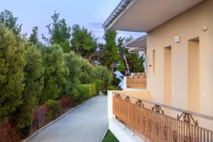 a balcony of a house with trees and bushes at Evripidis Hotel Afitos in Afitos