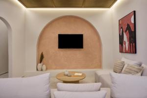 a living room with a couch and a tv on a wall at Alaia Boutique houses in Batsi