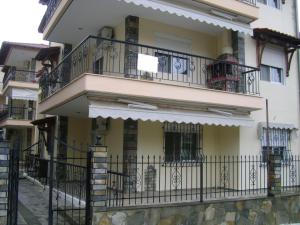 a building with balconies with people sitting on it at Katerina Apartments in Flogita