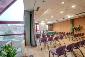 a conference room with chairs and tables and a window at Tulip Inn Turin South in Moncalieri