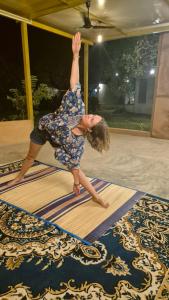 a woman doing a handstand on top of a rug at Zomad Hostels Pondicherry, Auroville Road in Auroville