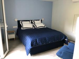 a bedroom with a bed with two pillows and a blue chair at 1 chambre indépendante dans maison in Tassin-la-Demi-Lune
