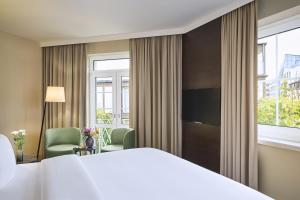 a hotel room with a bed and a large window at NH Düsseldorf Königsallee in Düsseldorf