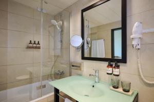 a bathroom with a sink and a shower at NH Düsseldorf Königsallee in Düsseldorf
