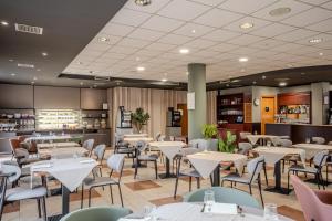 a restaurant with tables and chairs in a room at Tulip Inn Turin South in Moncalieri