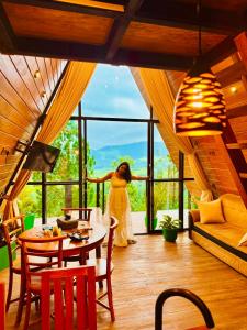 a woman standing in a room with a large window at Eco Cabana Bellwood Kandy in Kandy